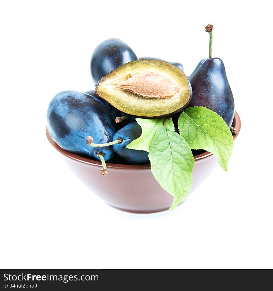 Bowl full of plums   on a white background