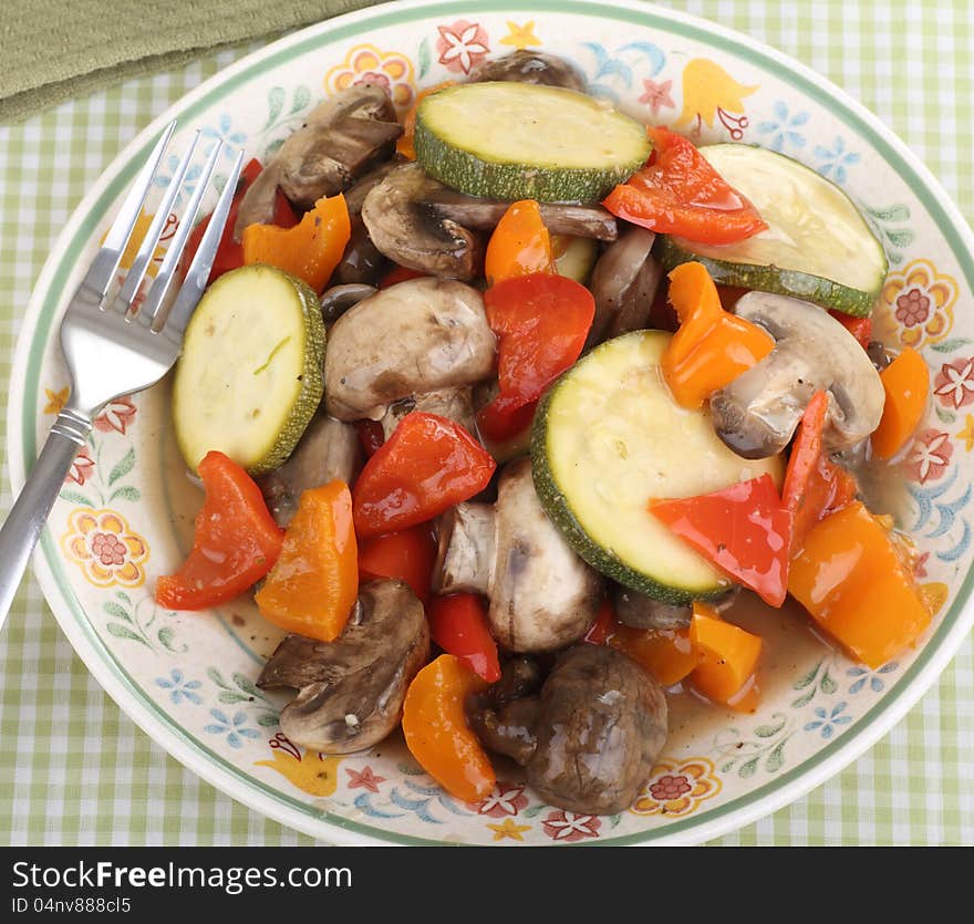 Top view of cooked peppers, mushrooms, and zucchini on a plate. Top view of cooked peppers, mushrooms, and zucchini on a plate