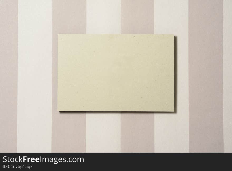 Cardboard rectangle on striped wallpaper, with shadow. Cardboard can easily be replaced in PS by any other image. Cardboard rectangle on striped wallpaper, with shadow. Cardboard can easily be replaced in PS by any other image.