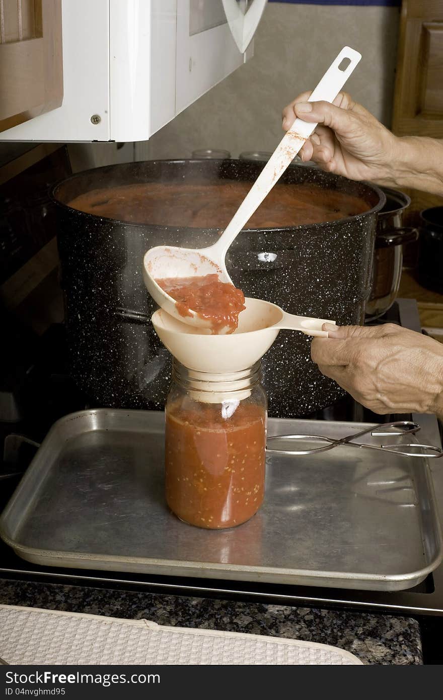 Filling jars with fresh tomatoes.