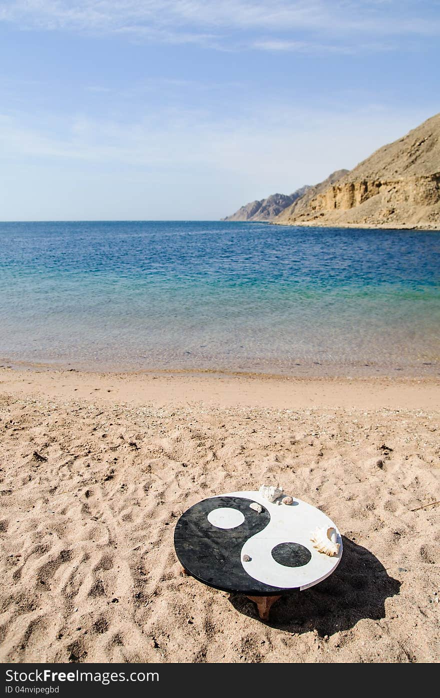 Landscape wit the symbol of Yin Yang on the beach