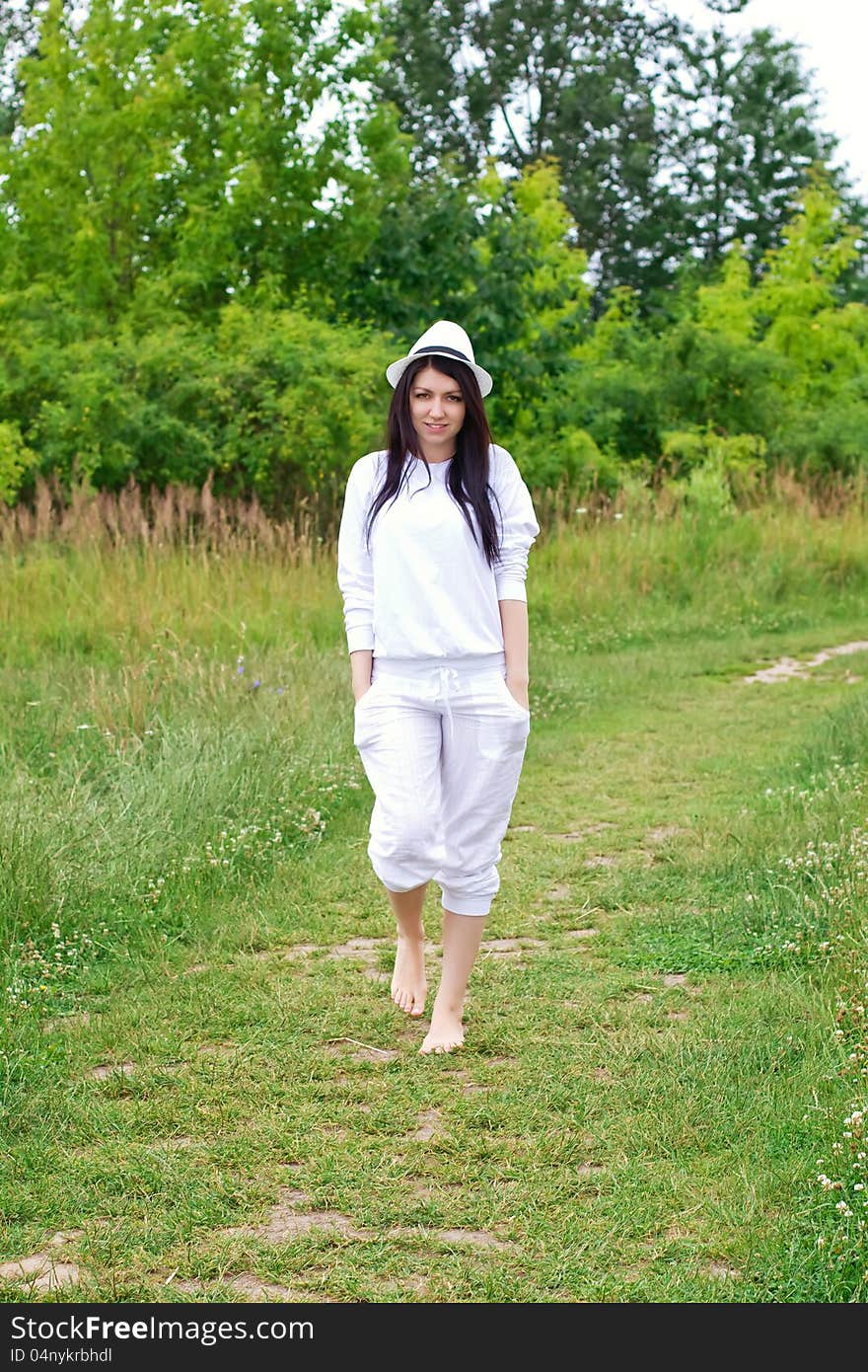 Young woman in white clothing walking outdoors. Young woman in white clothing walking outdoors