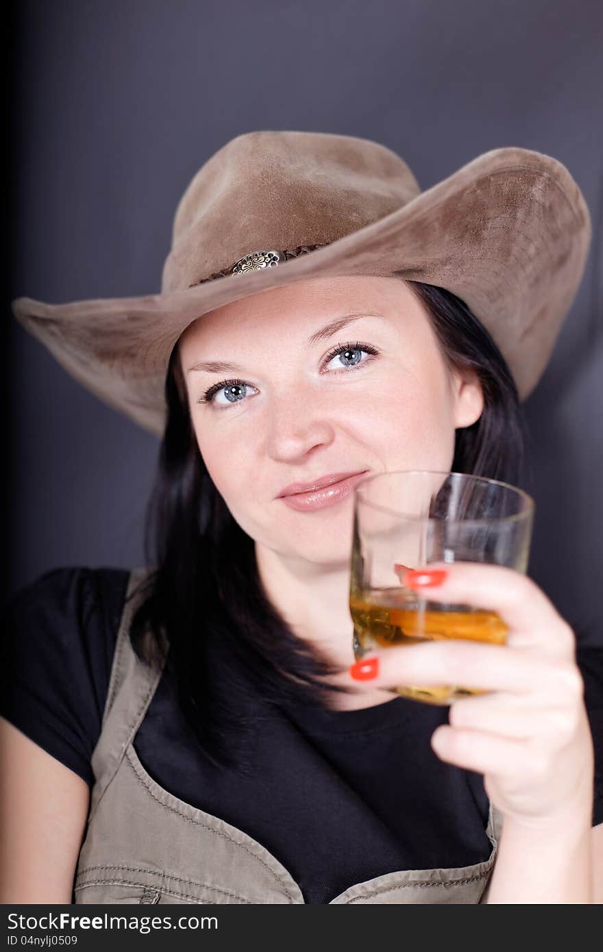 Girl drinking whiskey on dark background