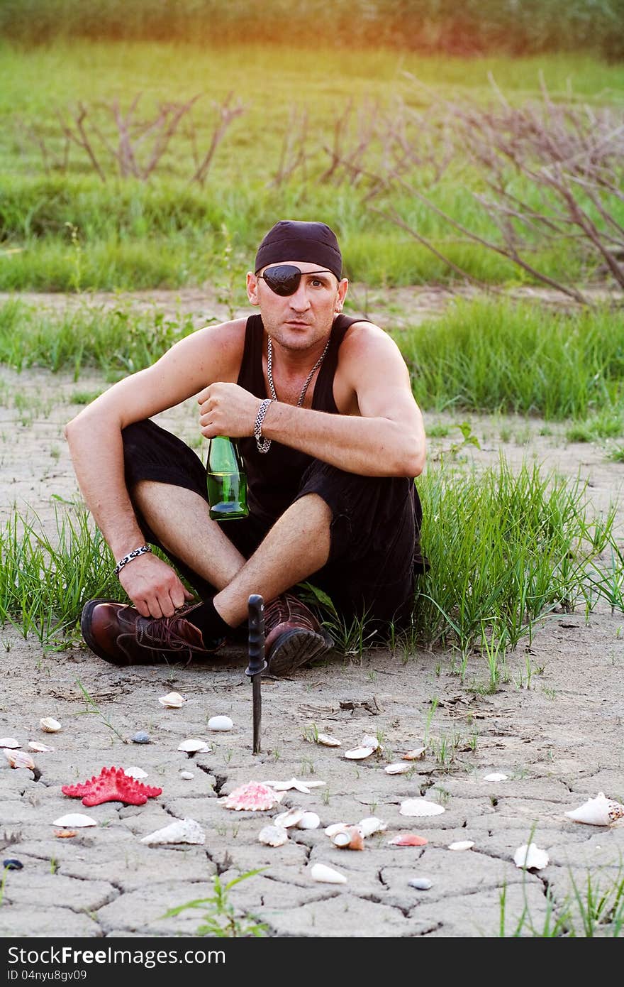 Pirate on land with a bottle of rum, threatening look