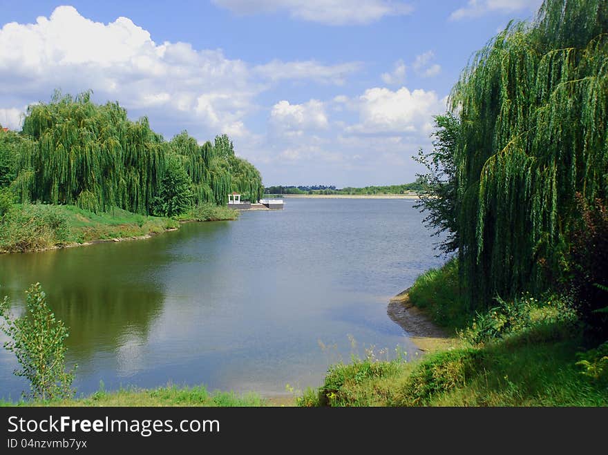 Blue Lake With Willows On The Bank