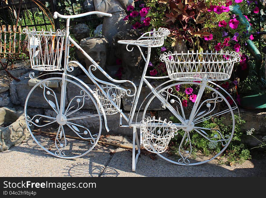 Pretty white metal bike with several wire baskets that can be used to display flowers or other items during the four seasons of the year. Pretty white metal bike with several wire baskets that can be used to display flowers or other items during the four seasons of the year.