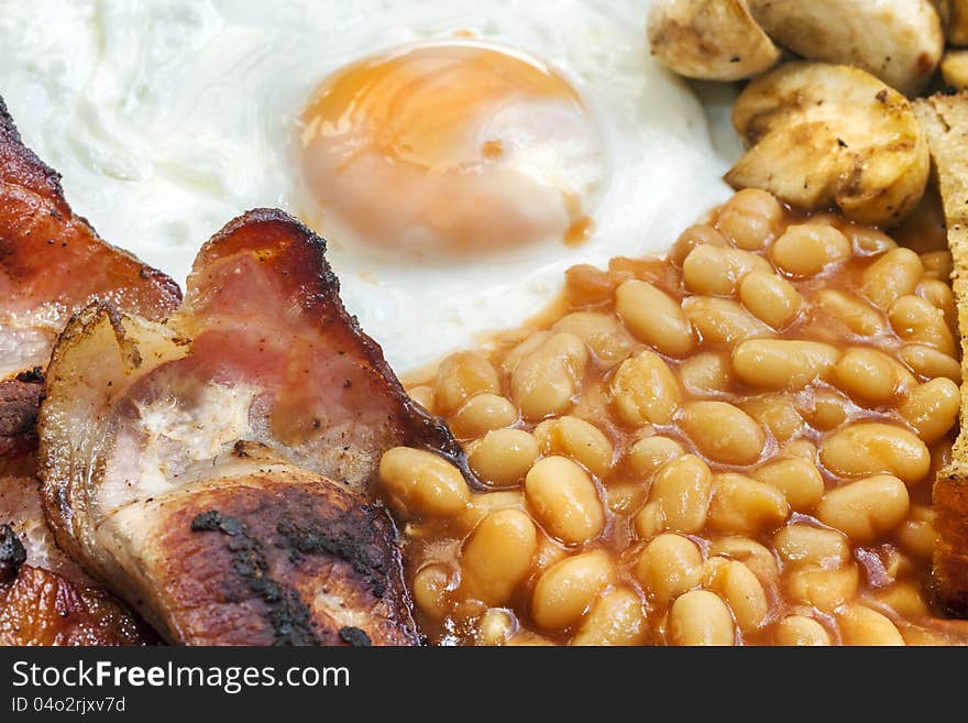 Typical Full English breakfast. Egg, Bacon, beans, mushroom and bacon. Typical Full English breakfast. Egg, Bacon, beans, mushroom and bacon.