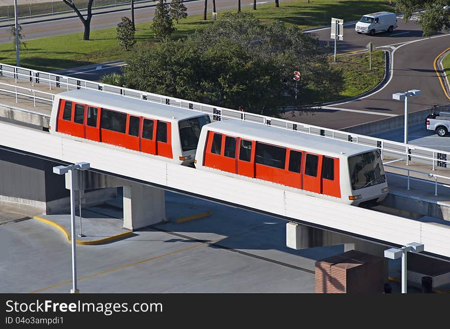 Red monorail train at an airport