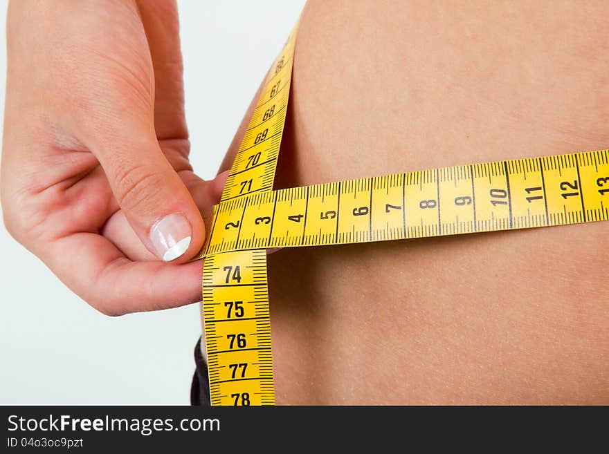 Slimming woman body in panties with measure on white background