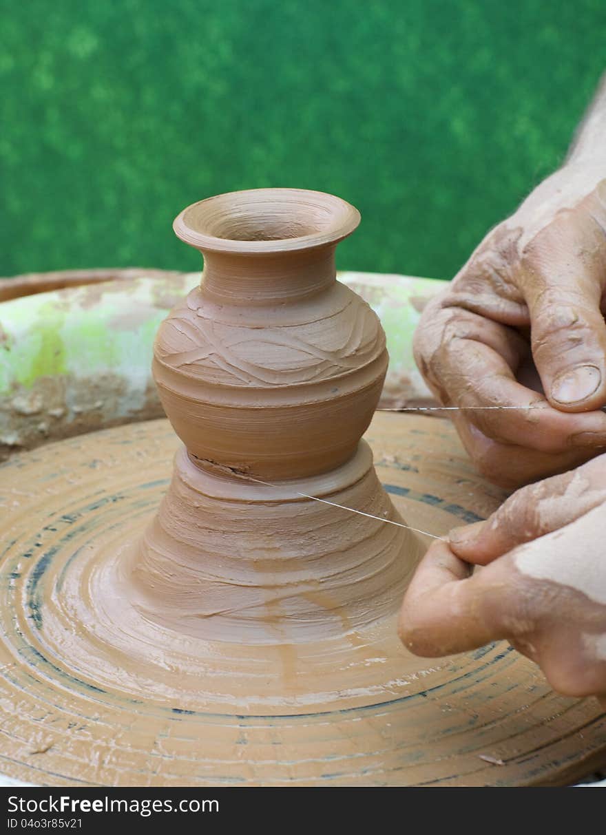 Hands of a potter, creating an earthen jar on the circle