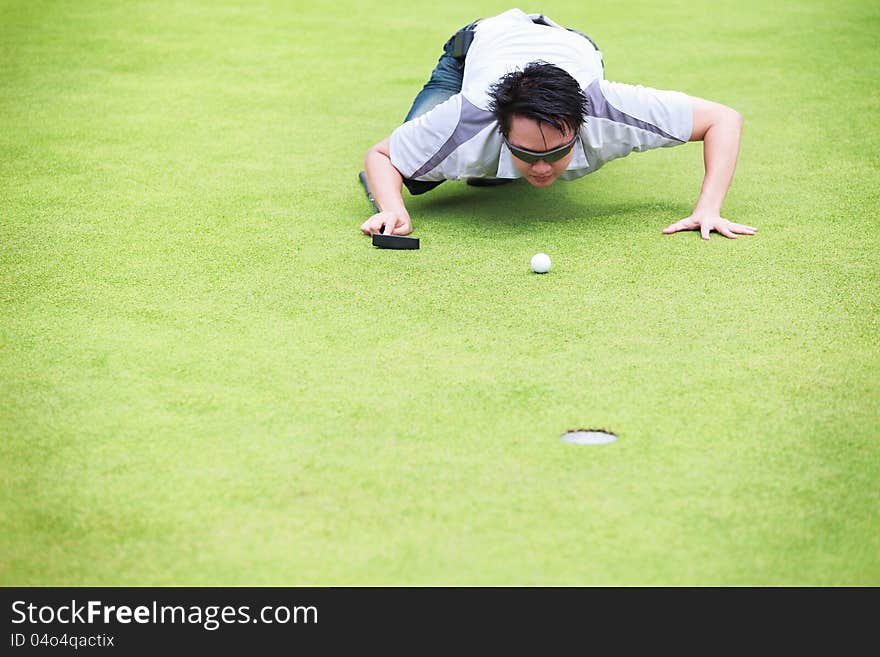 Golfer checking line of putt on green