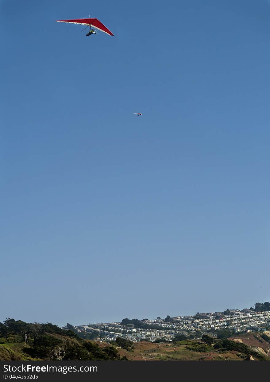 Red and white hang glider high up in the sky. Gorgeous weather and good thermal winds. Red and white hang glider high up in the sky. Gorgeous weather and good thermal winds