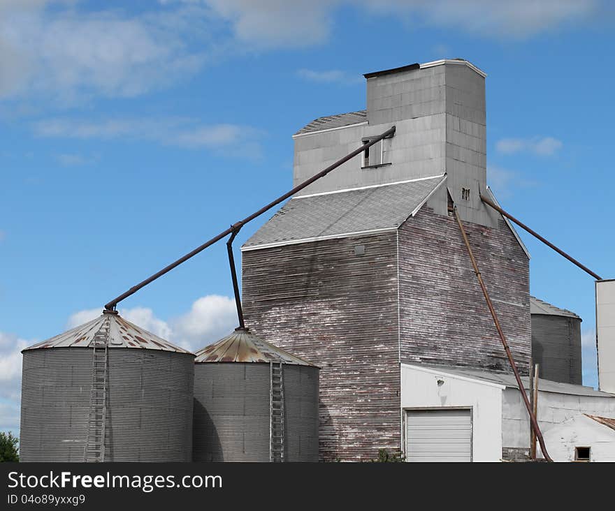 Old mid-west prairie wooden grain elevator complex, with metal grain storage bins. Old mid-west prairie wooden grain elevator complex, with metal grain storage bins.