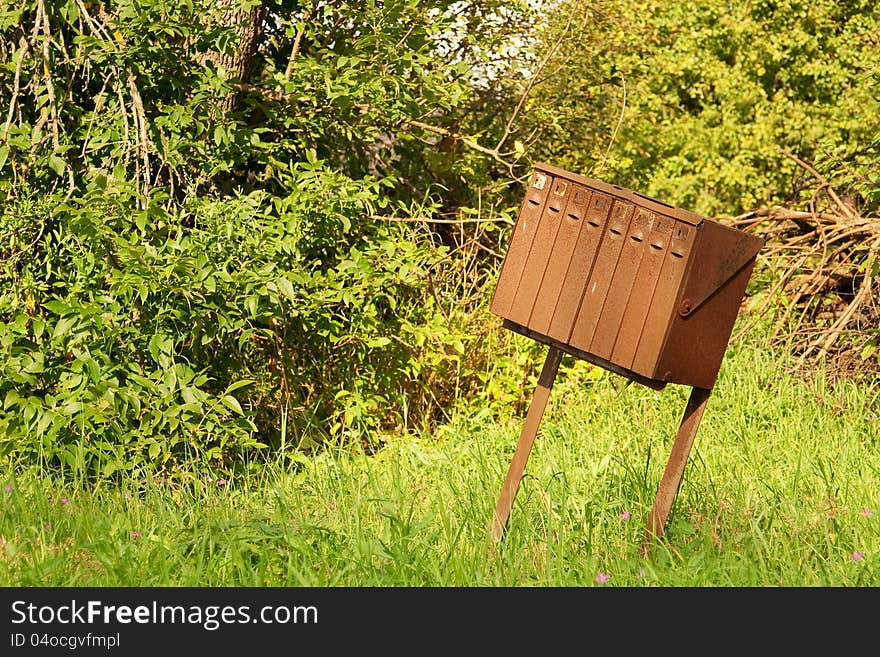 Old rusty mailboxes on the background of green foliage. Old rusty mailboxes on the background of green foliage