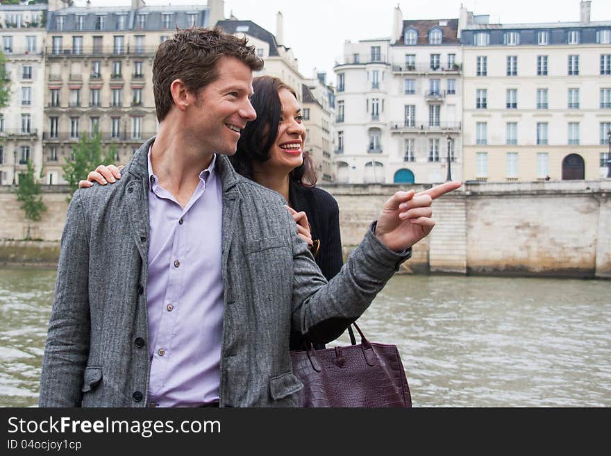 A men pointing to something, while a women looks on and laughs. A men pointing to something, while a women looks on and laughs.