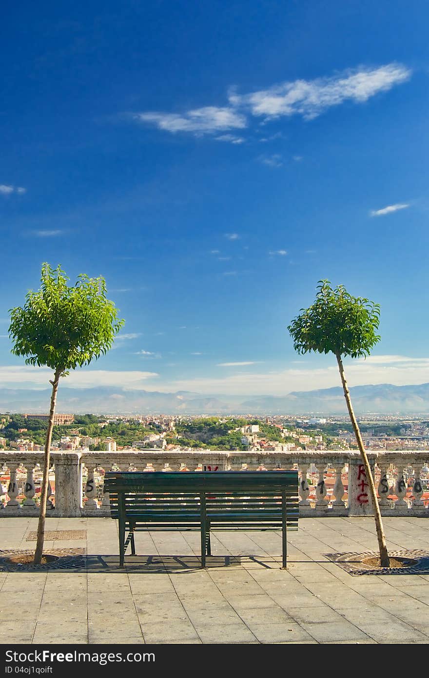 An iron bench and two trees on Vomero hill with view over Naples, Italy. An iron bench and two trees on Vomero hill with view over Naples, Italy