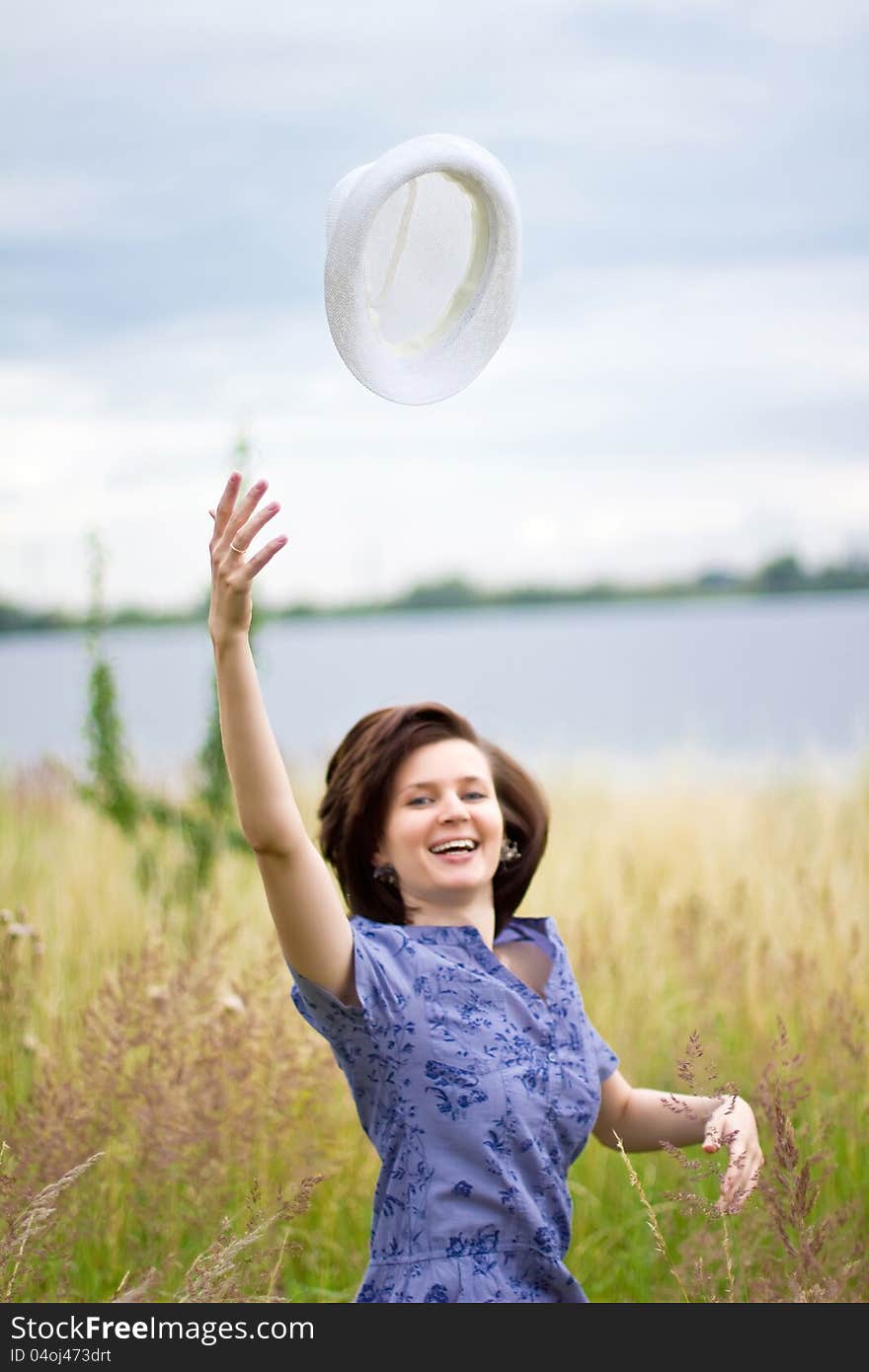 Happy young woman with hat in air