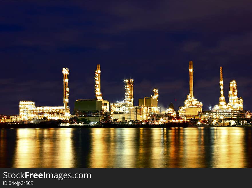 Oil refinery factory with reflection on the river.