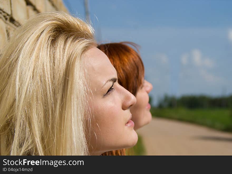 Two Girls Stand At The Wall