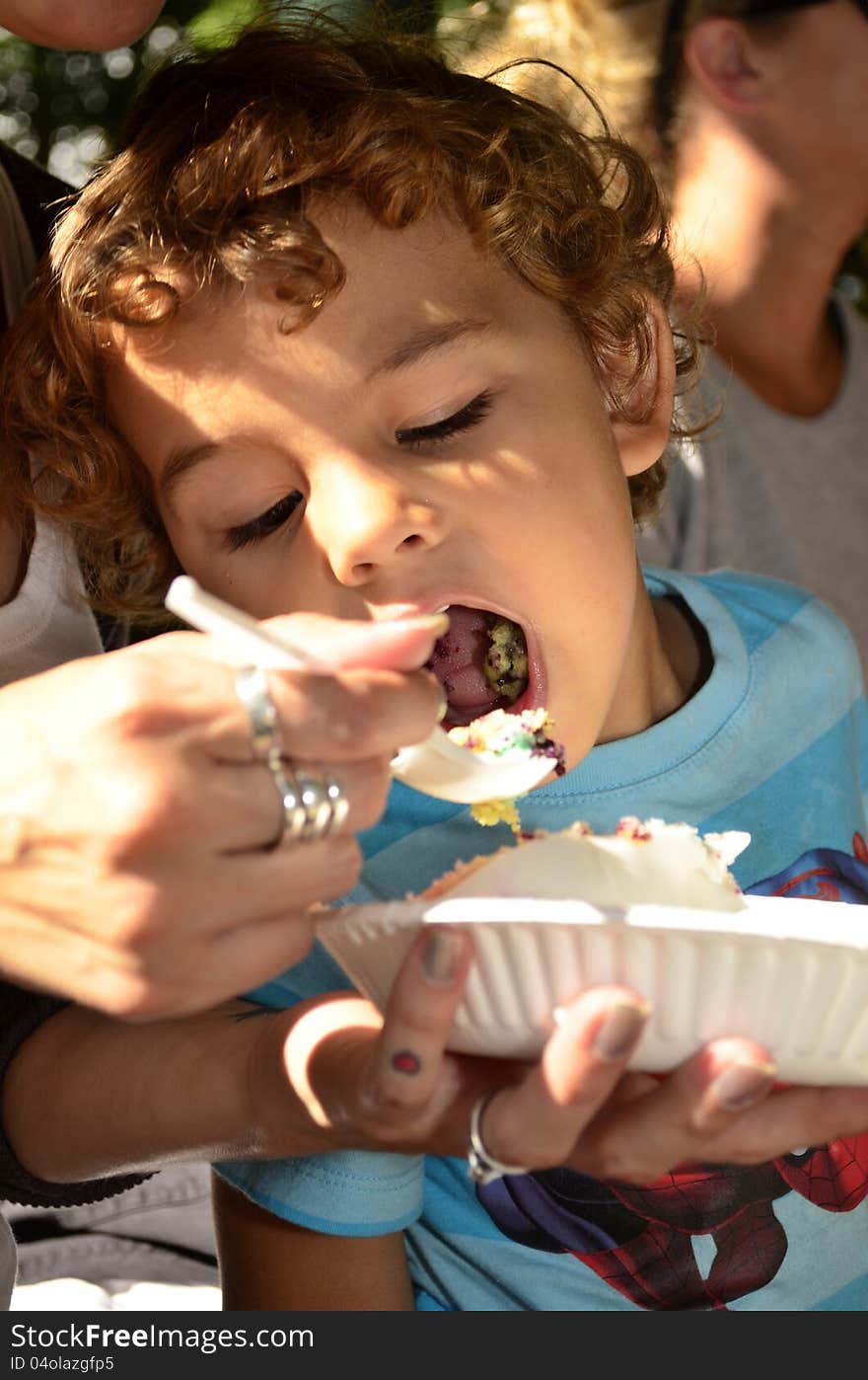 A young boy eating a cake