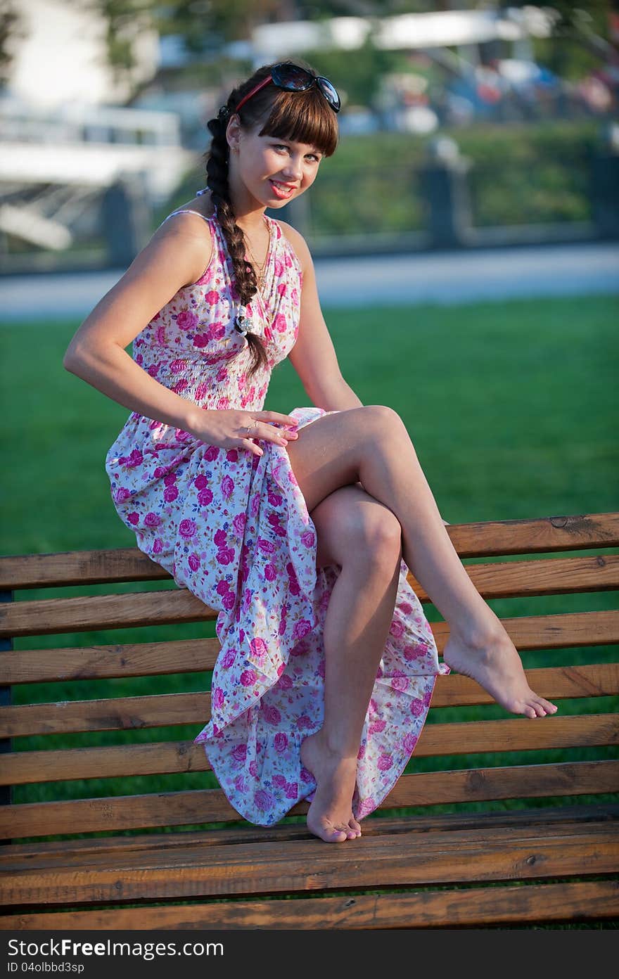 Photo a charming young girl posing in the park and shows her sexy bare legs. Photo a charming young girl posing in the park and shows her sexy bare legs