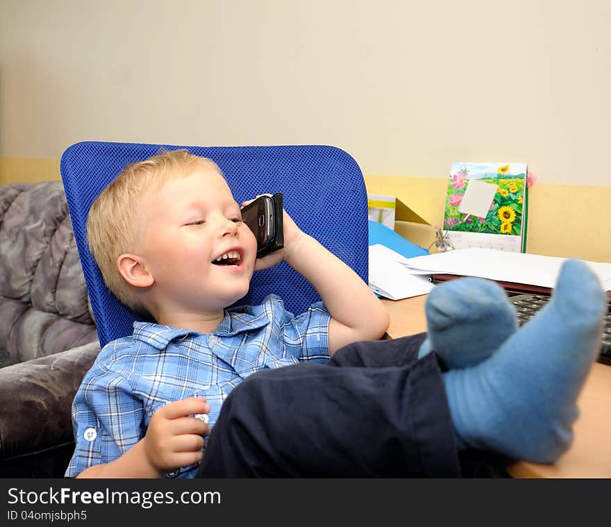 Small cute business boy with phone  in office