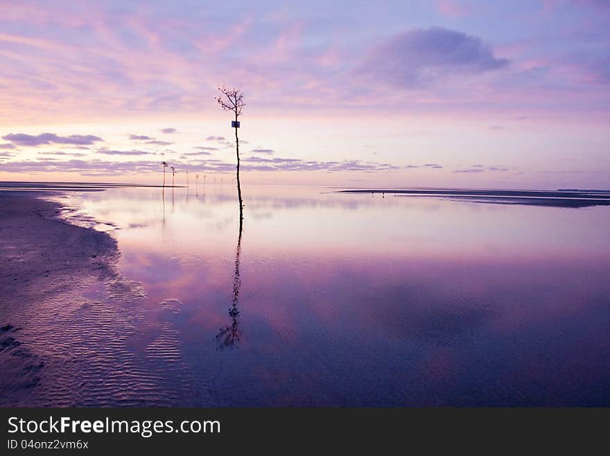 A purple light glows around the beach and sand at Orleans, Massachusetts on Cape Cod Bay. A purple light glows around the beach and sand at Orleans, Massachusetts on Cape Cod Bay.