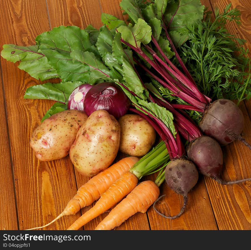 Heap of Raw Organic Potato, Carrot, Red Onion and Beet close up on wooden background. Heap of Raw Organic Potato, Carrot, Red Onion and Beet close up on wooden background