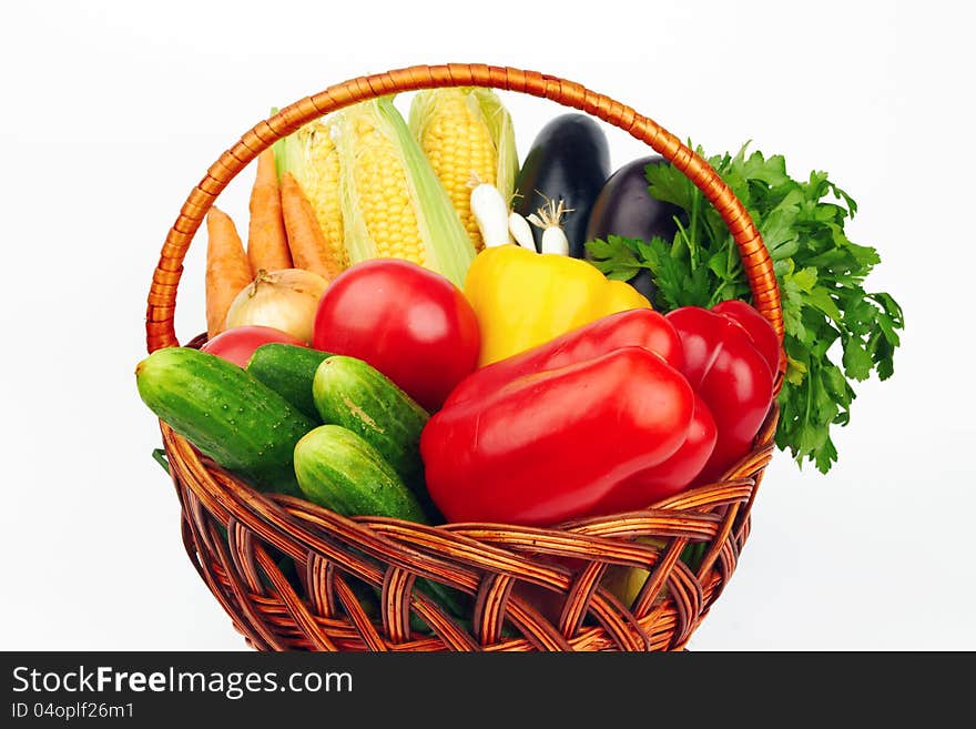 Basket with vegetables on white