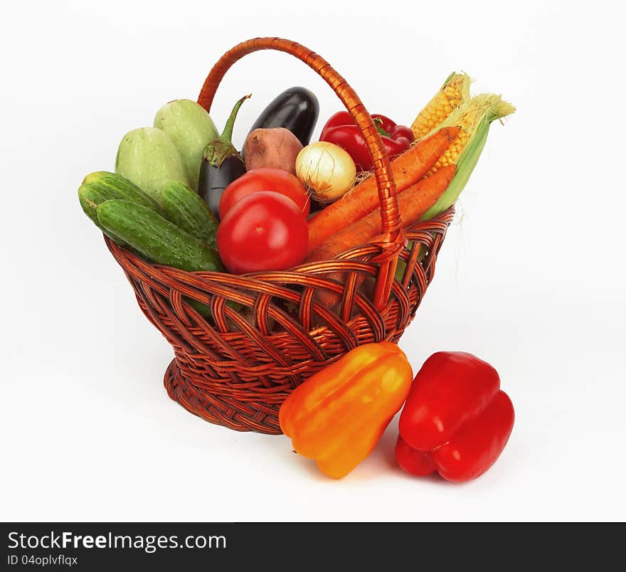 Basket with vegetables on white