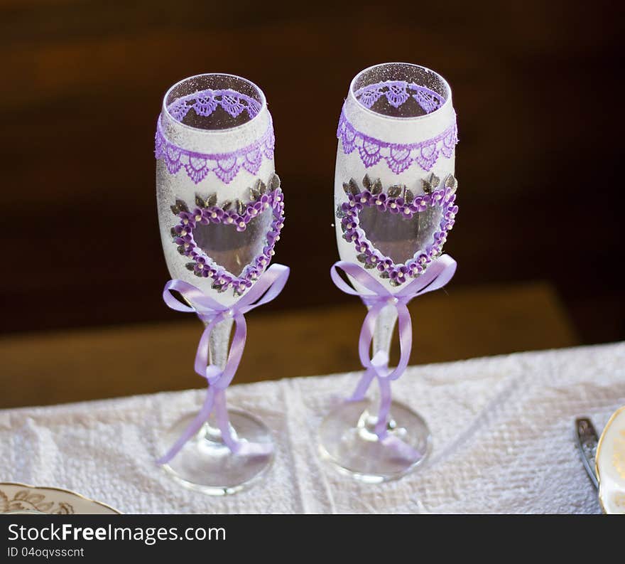 Couple of wedding glasses with flower, hearts and ribbon as love symbol for valentine day. Marriage photo background.