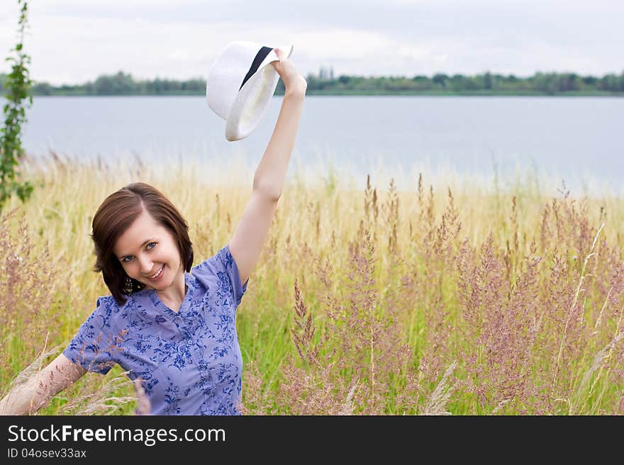 Slim shaped girl enjoying nature in the meadow by the lake