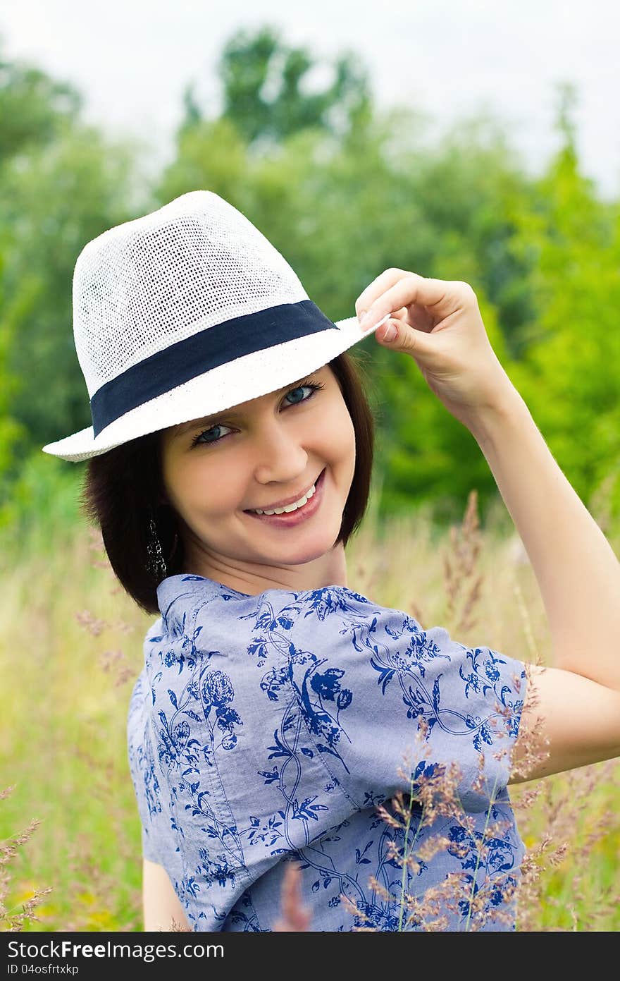 Laughing girl in white straw hat on the meadow. Laughing girl in white straw hat on the meadow