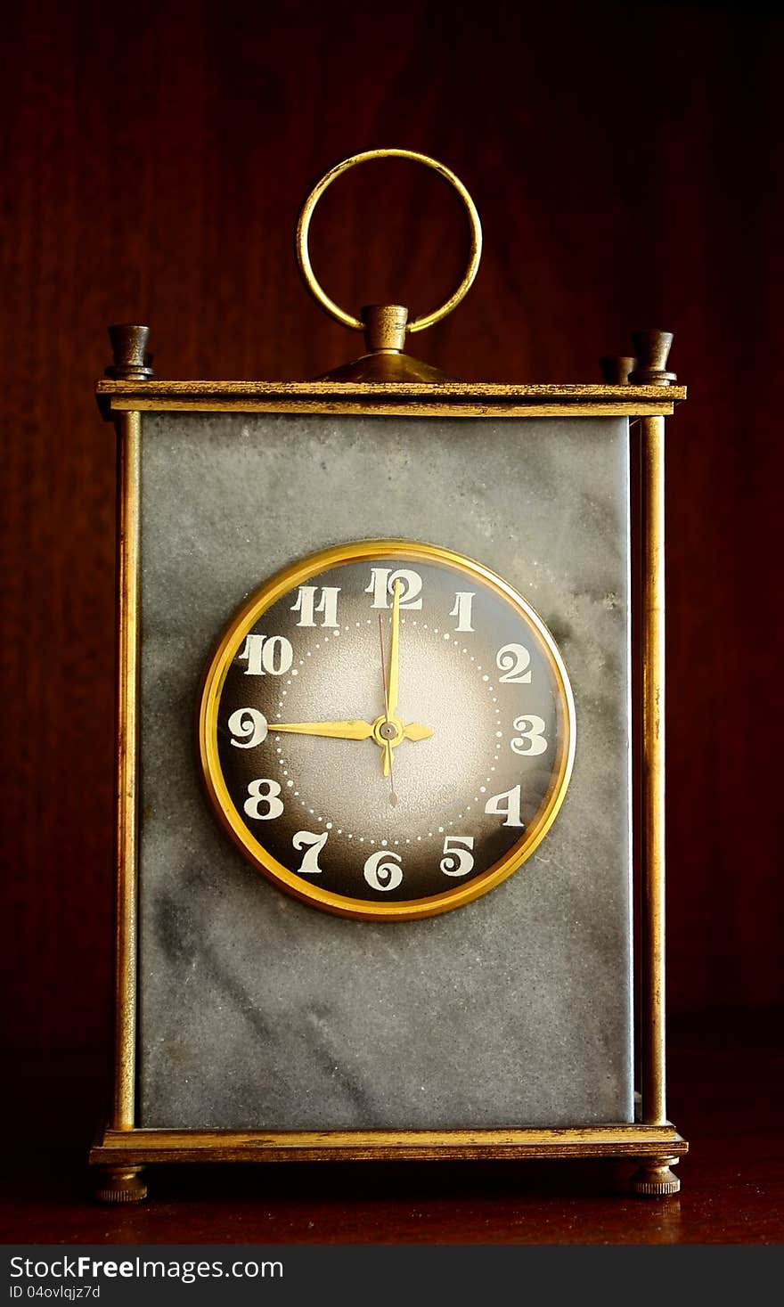 Face of an antique marble clock on a old wooden background