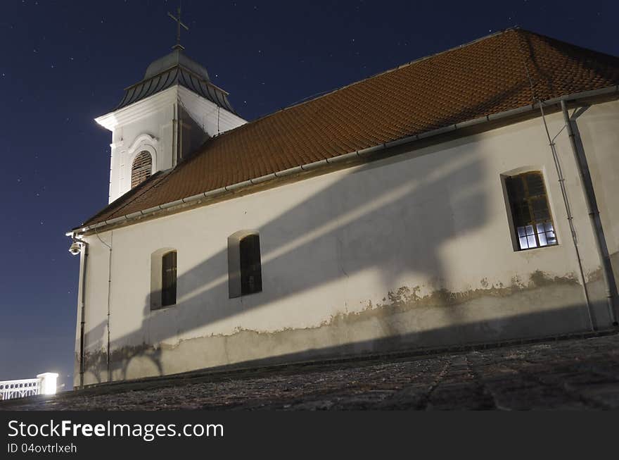 Night shot of the little church in Vrsac (small town in Srbija) with a bench reflection and stars above. Night shot of the little church in Vrsac (small town in Srbija) with a bench reflection and stars above.