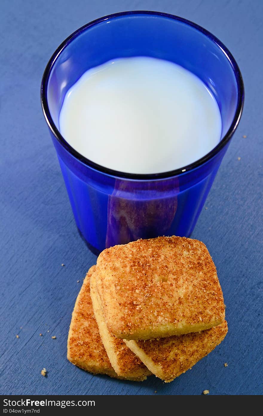 A glass of milk and cinnamon cookies. A glass of milk and cinnamon cookies