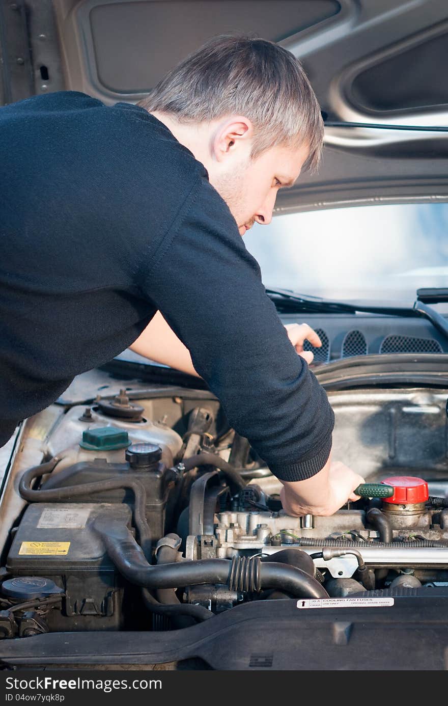 Young man fixing his car engine close-up