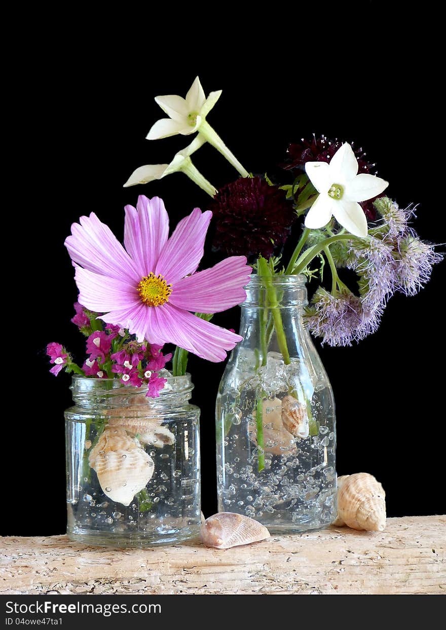 A Simple Arrangement of Flowers in a Jar and Bottle. A Simple Arrangement of Flowers in a Jar and Bottle