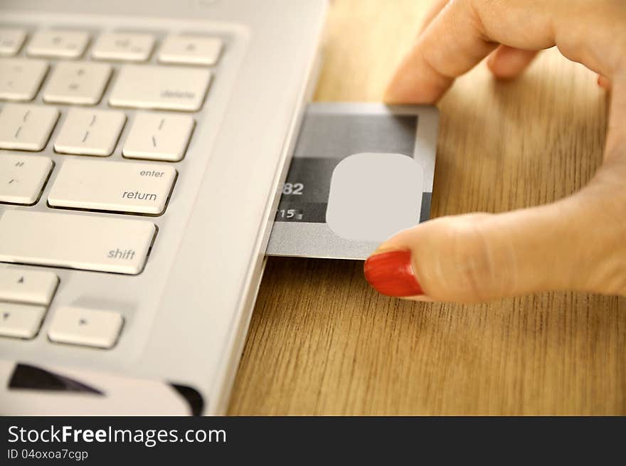 Credit card insert inside laptop on the wooden desk