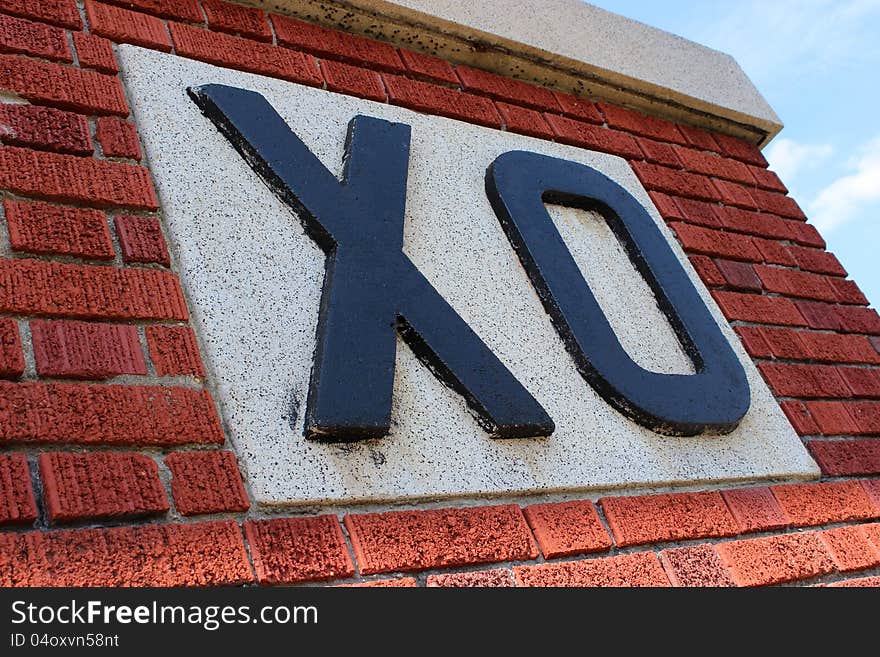 Big black letters of X and O in cement and bright red brick. Big black letters of X and O in cement and bright red brick.