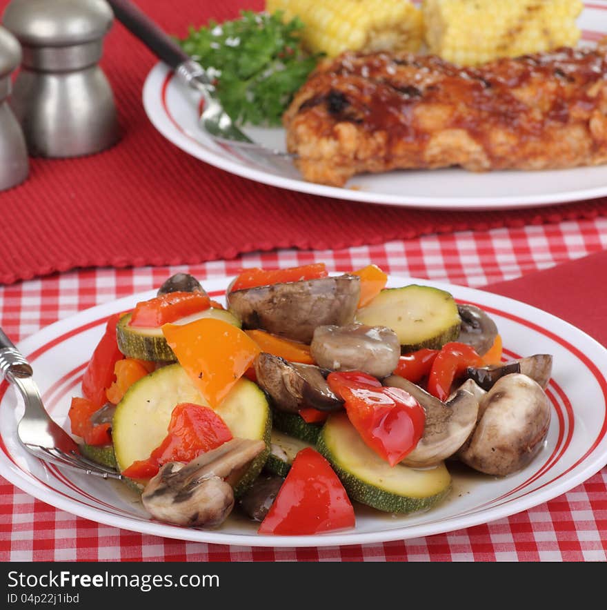 Cooked vegetables with red and orange peppers, zucchini, and mushrooms. Cooked vegetables with red and orange peppers, zucchini, and mushrooms