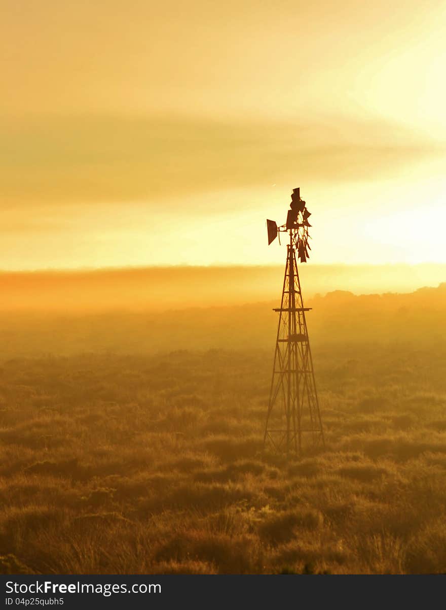 Landscape with Windmill water pump at sunrise