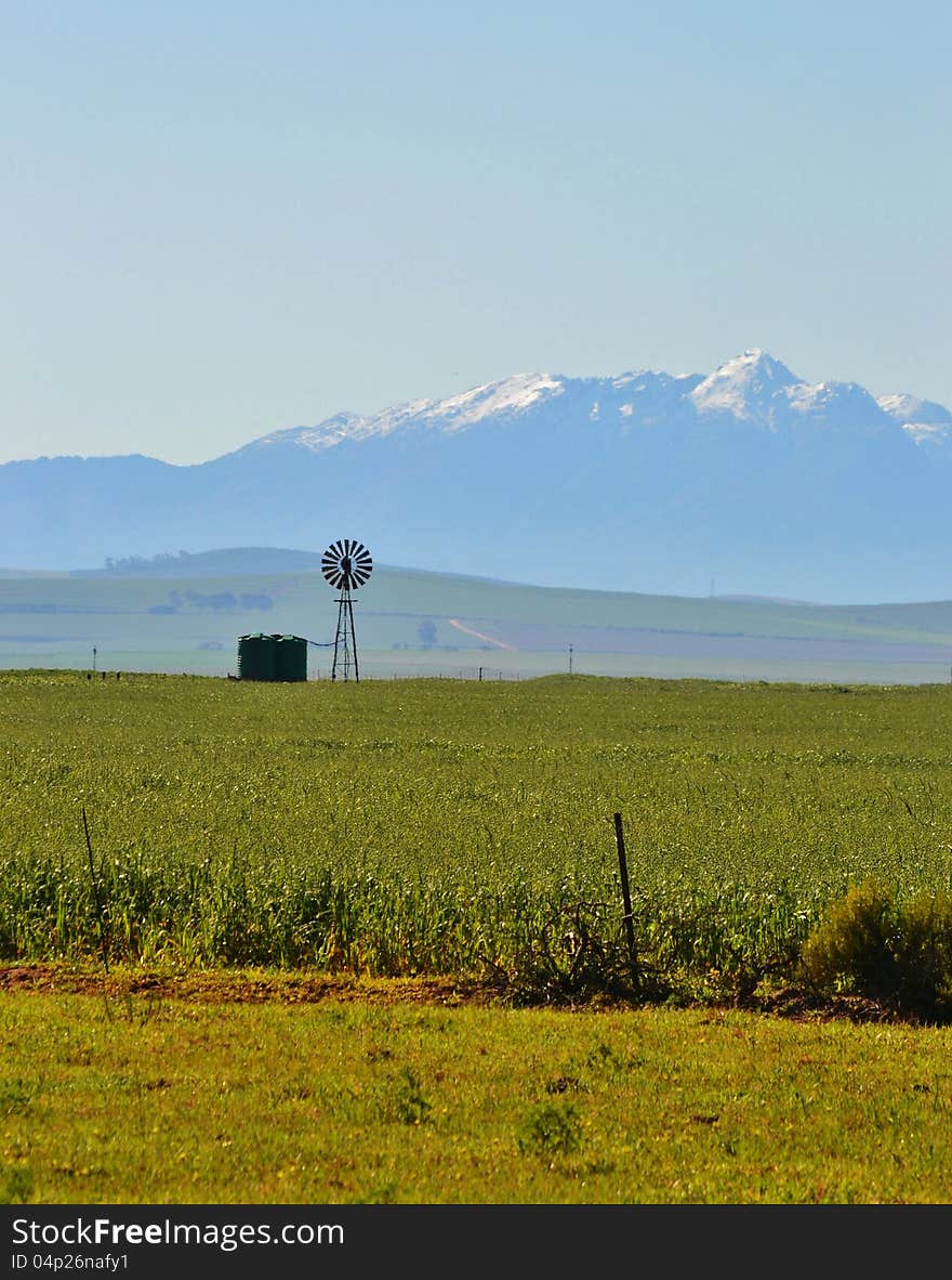 Landscape with windmill water pump and ceres mountains with snow