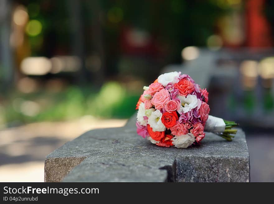 On the stone fence is a bouquet of roses for the bride. On the stone fence is a bouquet of roses for the bride