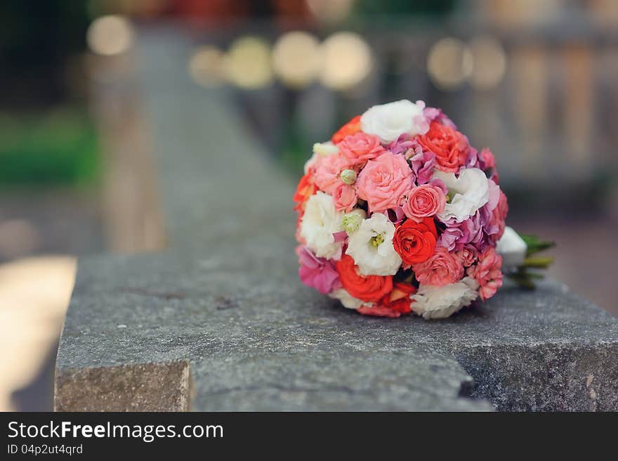 On the stone fence is a bouquet of roses for the bride. On the stone fence is a bouquet of roses for the bride