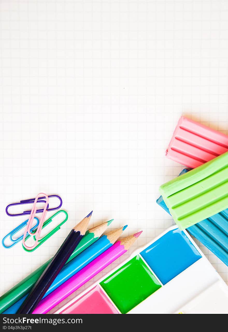 Blank paper on a school desk with various paints, pencils and plasticine. Blank paper on a school desk with various paints, pencils and plasticine