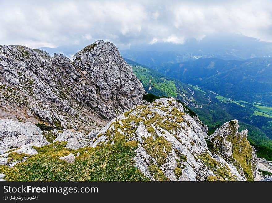 Rocks with cloudy sky behind on wide alley background,  Peca, Slovenia. Rocks with cloudy sky behind on wide alley background,  Peca, Slovenia