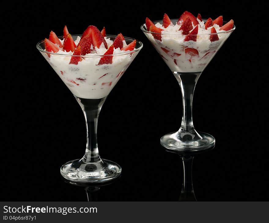 Strawberry with cream in two glasses.