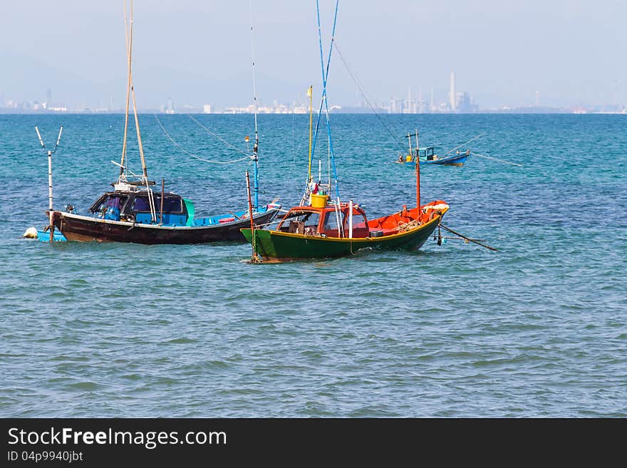 Anchored fishing boats with city in background