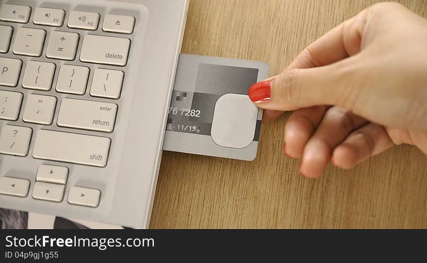 Credit card insert inside laptop on the wooden desk